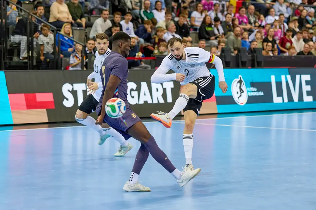 Christopher Wittig (Deutschland) im Abschluss gegen Jeff Adubofour (England), begleitet von Maximilian Grünberg, beim Futsal-Länderspiel Deutschland gegen England.