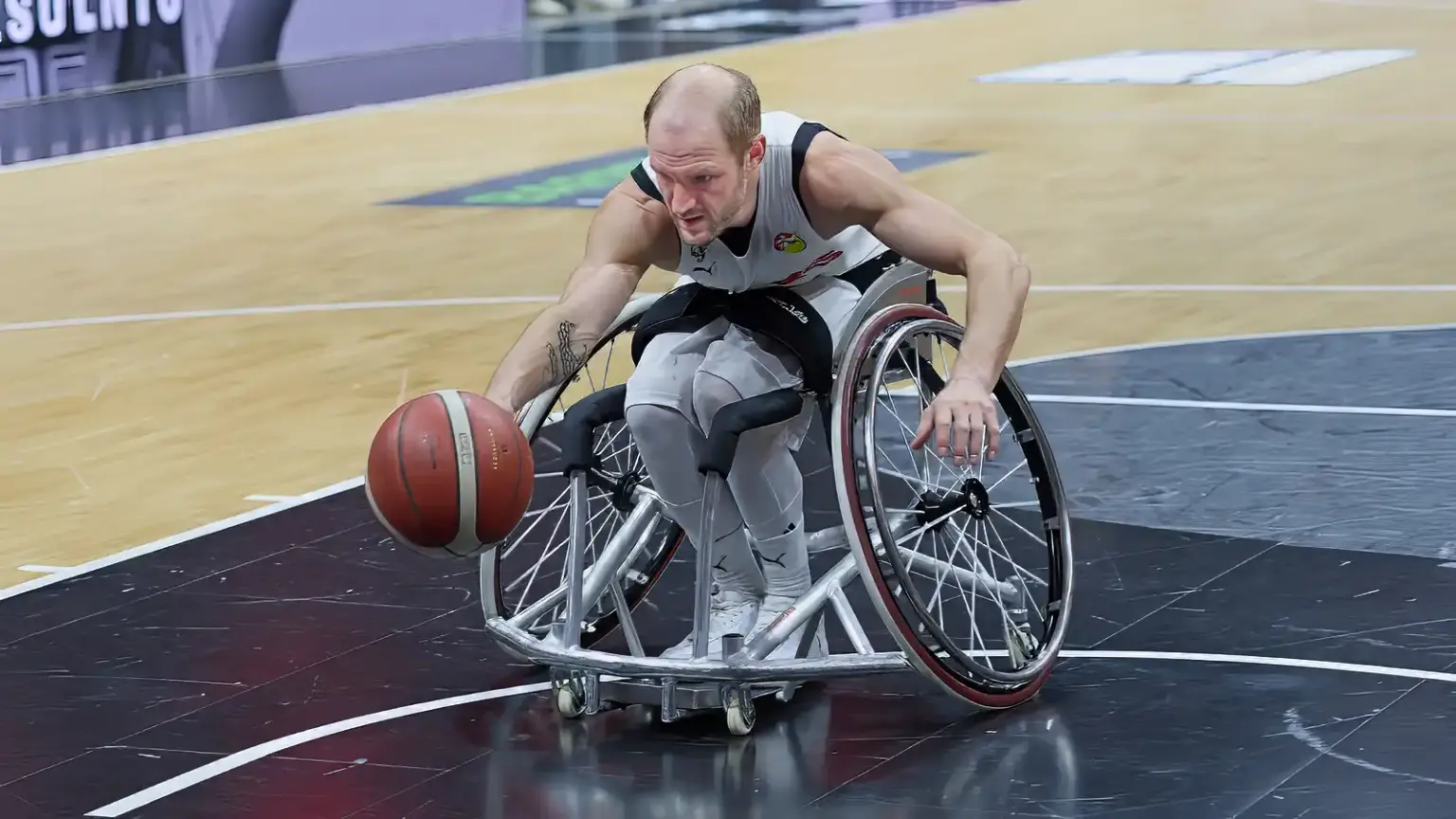 Rollstuhlbasketball fotografieren: Basketballspieler dribbelt mit hoher Geschwindigkeit während eines RBBL2-Spiels