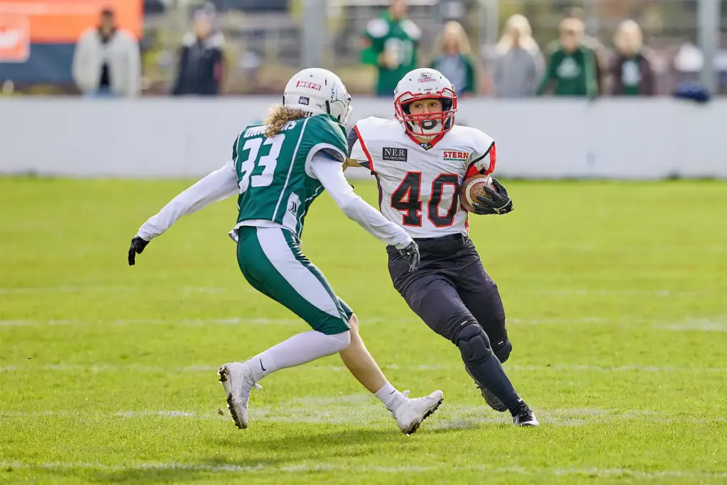 Eine Spielerin der Scorpions Sisters läuft beim Ladiesbowl mit dem Football über das Feld, während eine Spielerin der Schwäbisch Hall Unicorns Women zum Tackling ansetzt.